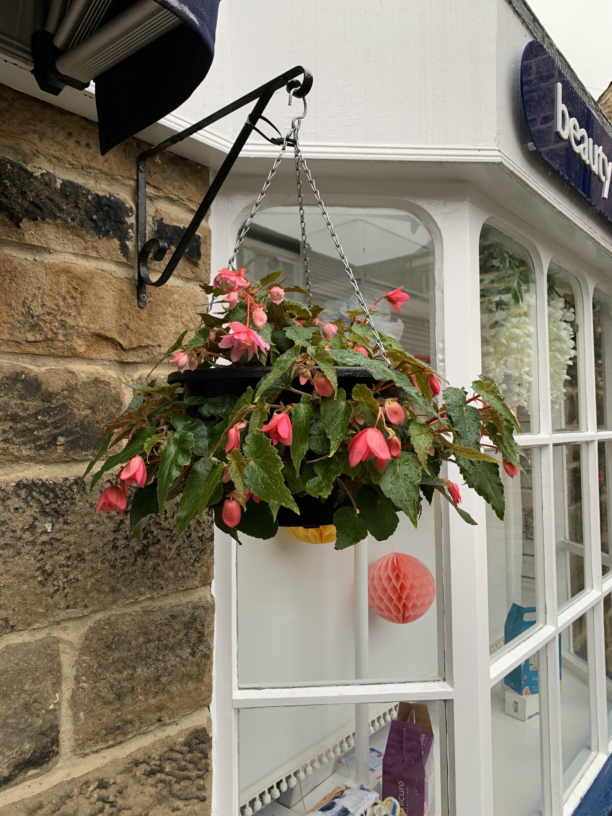 The doorway, blue trim and hanging basket at Beauty Within
